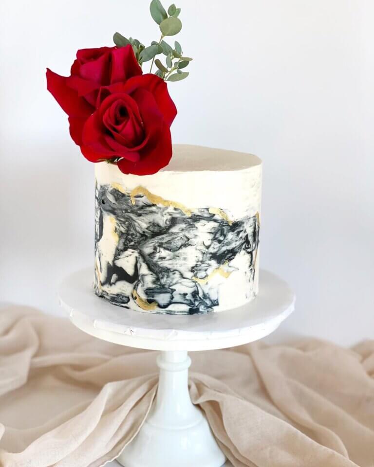 Marbled black and white cake with red rose.